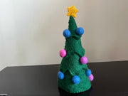 Green Christmas tree with pink and blue small felt balls and has yellow color star on top.