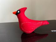 Cardinal bird toy in red with orange color nose and white lining of thread 