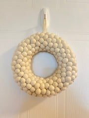 White felted Christmas Wreath hanging on a wall